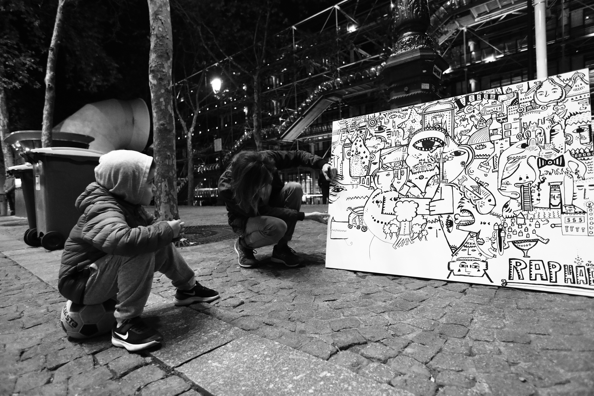Space Raphaël working beside a black and white artwork at night