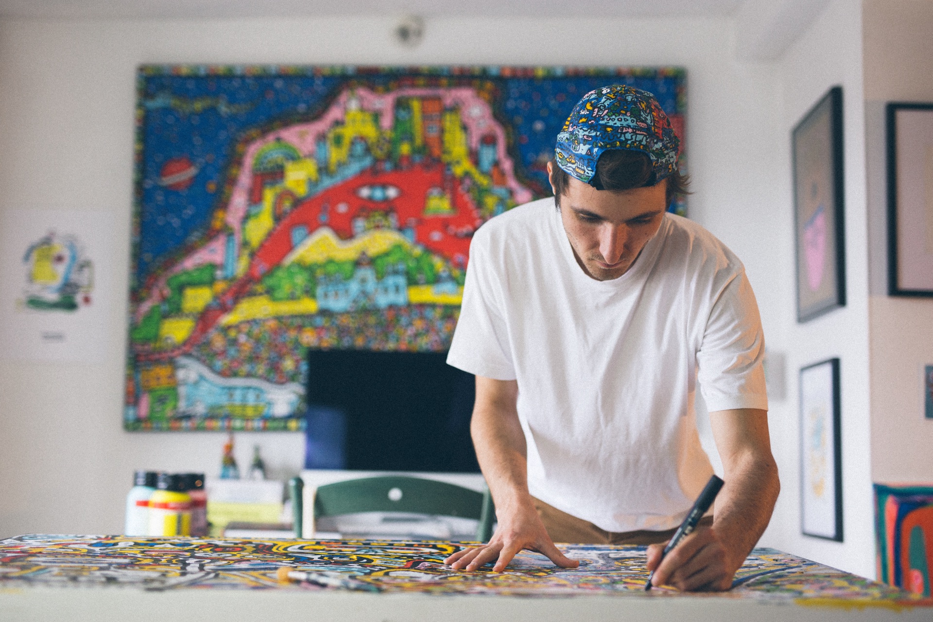 Space Raphaël working in front of a finished original artwork